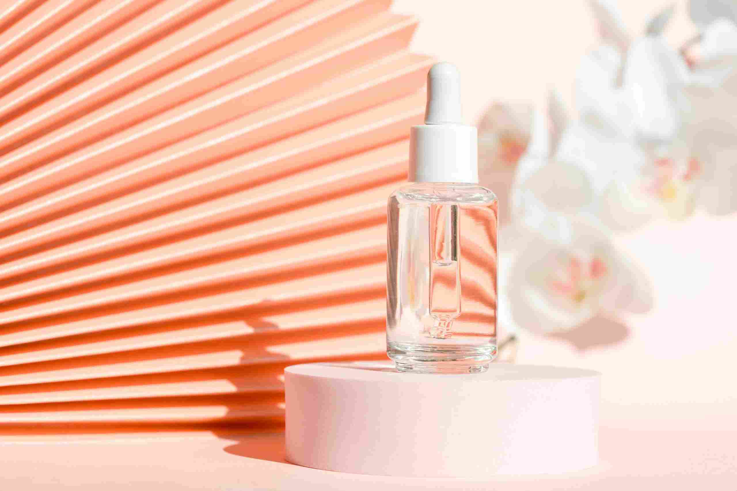 using squalane in skin and hair care, image of squalane in a serum bottle with pink background